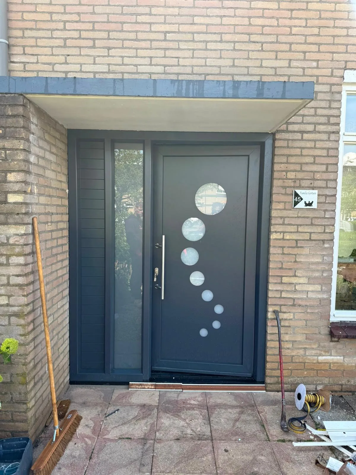 Antraciet voordeur met ronde glasopeningen